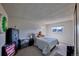 Neutral bedroom with a bed, accent furniture, and a window view at 1922 S Ivory Way, Aurora, CO 80013