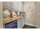Bar area with wine fridge, granite counter, tile backsplash, and cabinetry at 6878 Northstar Ct, Castle Rock, CO 80108