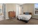 Bedroom with neutral walls, a bed with blue pillows, a dresser, and closet access at 6878 Northstar Ct, Castle Rock, CO 80108