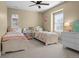 Bright bedroom featuring twin beds, ceiling fan, and a large window for natural light at 6878 Northstar Ct, Castle Rock, CO 80108