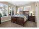 Bedroom featuring neutral walls, carpet, three large windows for natural light and a dark wood bed frame and side tables at 6878 Northstar Ct, Castle Rock, CO 80108