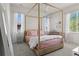 Bright bedroom featuring a wooden canopy bed, soft pink bedding, neutral walls and carpet and lots of natural light at 6878 Northstar Ct, Castle Rock, CO 80108