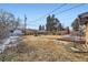 Wide backyard with mature trees, play equipment, and outdoor seating at 1519 S Lowell Blvd, Denver, CO 80219