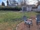 Landscaped backyard featuring a relaxing hammock, storage sheds, raised garden beds, and comfortable seating area at 1519 S Lowell Blvd, Denver, CO 80219
