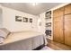 Comfortable bedroom with hardwood floors and built-in storage and display shelving at 1519 S Lowell Blvd, Denver, CO 80219