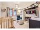 Charming Bedroom featuring a crib, rocking chair, and clothing rack with colorful accents at 1519 S Lowell Blvd, Denver, CO 80219