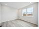 Bright bedroom with light gray wood floors, recessed lighting, and large windows providing ample light at 1263 Rhett Dr, Erie, CO 80026