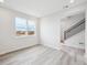 Bright bedroom with light gray wood floors, recessed lighting, and large windows providing ample light at 1263 Rhett Dr, Erie, CO 80026