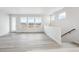 Spacious living room with light gray wood floors and large windows offering abundant natural light at 1263 Rhett Dr, Erie, CO 80026