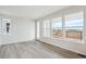 Spacious living room with light gray wood floors and large windows offering abundant natural light at 1263 Rhett Dr, Erie, CO 80026