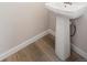 A modern pedestal sink in a powder room with wood-style flooring at 1263 Rhett Dr, Erie, CO 80026
