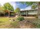 Well-maintained backyard featuring covered deck, mature trees and lush landscaping at 7046 W 62Nd Pl, Arvada, CO 80003