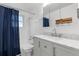 Bathroom with shower and tub combination, sink and cabinet with countertop at 7046 W 62Nd Pl, Arvada, CO 80003