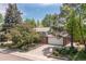 Charming two-story home surrounded by mature trees and landscaping, featuring a brick facade and two-car garage at 7046 W 62Nd Pl, Arvada, CO 80003
