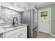 Kitchen sink with stainless steel refrigerator and a door to the outside at 7046 W 62Nd Pl, Arvada, CO 80003