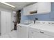 Functional laundry room with white cabinets, and modern washer and dryer at 7046 W 62Nd Pl, Arvada, CO 80003