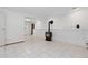 Open living space with a tile floor, a wood burning stove, and white walls at 7046 W 62Nd Pl, Arvada, CO 80003