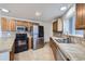 Charming kitchen featuring stainless steel appliances, wooden cabinets, and tile countertops at 8100 W Quincy Ave # D, Littleton, CO 80123