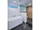 Elegant bathroom with a soaking tub, wood-look shower, and black marble-patterned tile floors at 1819 N Grove St, Denver, CO 80204