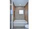 Modern bathroom featuring a sleek bathtub, textured gray tile, wood-look side panels, and a recessed shelf at 1819 N Grove St, Denver, CO 80204