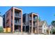 Modern townhomes featuring brick and metal accents, multiple balconies, and stone retaining walls at 1819 N Grove St, Denver, CO 80204