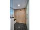 Modern shower with a sleek glass enclosure, wooden-look tile, and a black tiled shower floor with bench at 1819 N Grove St, Denver, CO 80204