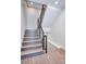 Modern staircase featuring wood treads, gray risers, and a sleek black metal railing at 1819 N Grove St, Denver, CO 80204