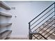 Staircase with black metal railing, open shelving, and wood-look floors at 1819 N Grove St, Denver, CO 80204