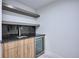 Stylish wet bar featuring granite countertops, dark backsplash, wooden cabinets, and a beverage cooler at 1819 N Grove St, Denver, CO 80204