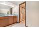 Bathroom featuring double sinks, granite countertops, wood cabinets, a glass shower, and neutral decor at 7582 S Newport Ct, Centennial, CO 80112