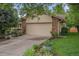 Charming home exterior features a two-car garage with stone accents and landscaped yard at 7582 S Newport Ct, Centennial, CO 80112