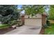 Charming home exterior features a two-car garage with stone accents and landscaped yard at 7582 S Newport Ct, Centennial, CO 80112
