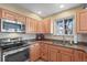 Well-equipped kitchen featuring stainless steel appliances, granite counters, and warm-toned cabinetry at 10588 E Park Mtn, Littleton, CO 80127