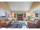 Inviting living room with a brick fireplace, built-in bookshelves, and lots of natural light at 10588 E Park Mtn, Littleton, CO 80127