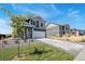 A modern home with a spacious driveway and a well manicured lawn on a sunny day at 2233 Base St, Fort Lupton, CO 80621
