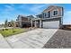 A modern home with a spacious driveway and a well manicured lawn on a sunny day at 2233 Base St, Fort Lupton, CO 80621