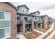 Street view of modern townhouses featuring brick and gray siding with individual patios at 5187 S Fairplay St, Aurora, CO 80015