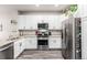 Modern kitchen featuring stainless steel appliances, white cabinets, and granite countertops at 5187 S Fairplay St, Aurora, CO 80015