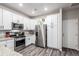 Modern kitchen with stainless steel appliances, granite countertops, and white cabinets at 5187 S Fairplay St, Aurora, CO 80015