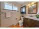 Well-lit bathroom with a dark wood vanity, medicine cabinet, and earth-toned tiles at 6940 S Uinta St, Centennial, CO 80112