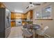 Bright eat-in kitchen with stainless steel appliances, wood cabinets, and a tile backsplash at 6940 S Uinta St, Centennial, CO 80112