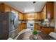 Well-equipped kitchen with stainless steel appliances, wood cabinets, and a cozy breakfast nook at 6940 S Uinta St, Centennial, CO 80112