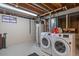 Basement laundry room area featuring a modern washer, dryer, and water heater at 6940 S Uinta St, Centennial, CO 80112