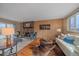 Inviting living room featuring a stone fireplace, hardwood floors, and ample natural light at 6940 S Uinta St, Centennial, CO 80112