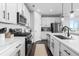 Well-lit kitchen with stainless steel appliances, white cabinets, and a patterned backsplash at 27491 E 10Th Dr, Aurora, CO 80018