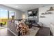 Cozy living room features a stone fireplace, dark hardwood floors, and a sliding glass door to the backyard at 27491 E 10Th Dr, Aurora, CO 80018