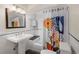Charming bathroom with a pedestal sink, tiled shower, and decorative shower curtain at 2591 Albion St, Denver, CO 80207