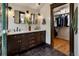 Elegant bathroom boasts a double vanity with dark wood cabinets, black tiled floors and a walk-in closet at 2591 Albion St, Denver, CO 80207