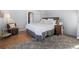 Cozy bedroom with hardwood floors and soft rug features a comfortable bed, side tables, and ample natural light at 2591 Albion St, Denver, CO 80207
