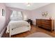 Cozy bedroom with a white bed frame, hardwood floors, a desk and a dresser at 2591 Albion St, Denver, CO 80207